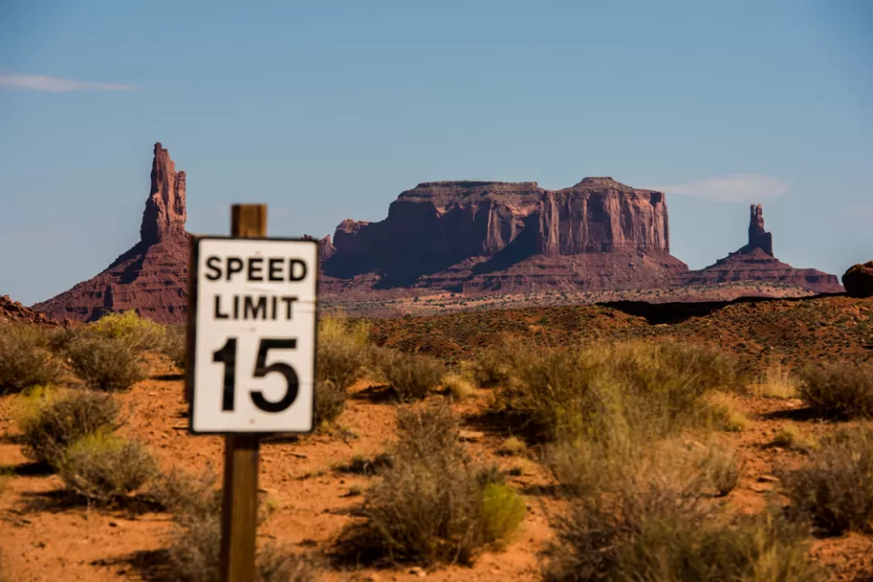 View of 15mph speed limit sign with Monument Valley mesas in the background